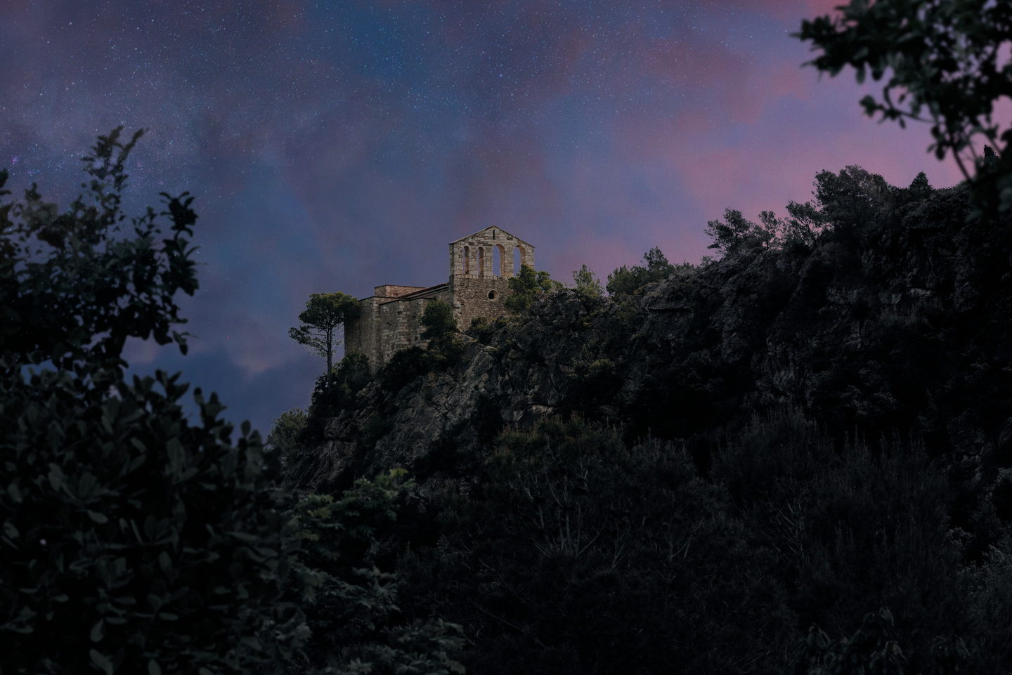 El Santuari de Foix retallat al capvespre, amb la lluna creixent sobre el cel rosa i lila